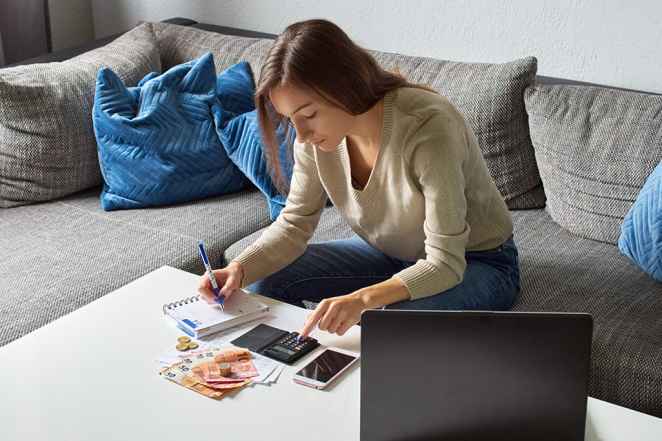 Foto: Frau mit Taschenrechner und Bargeld